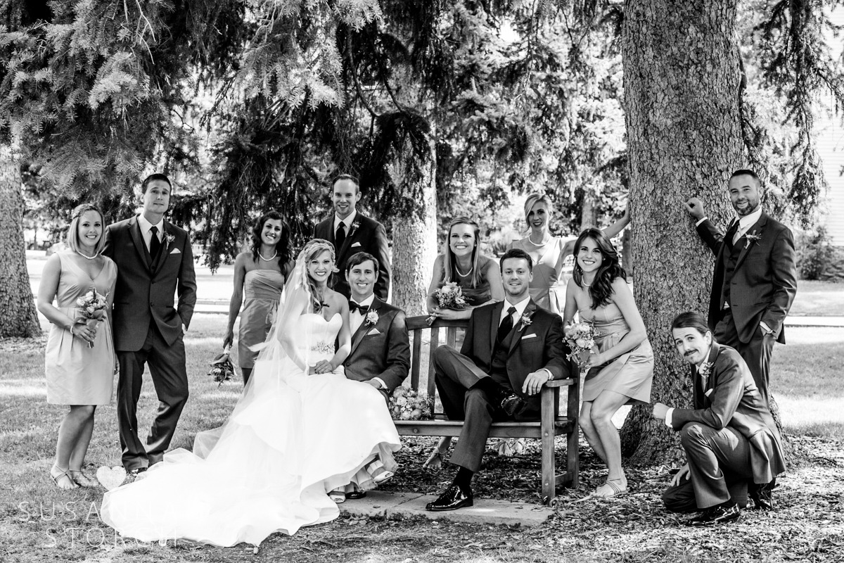 b/w photo of a wedding party posing under big trees