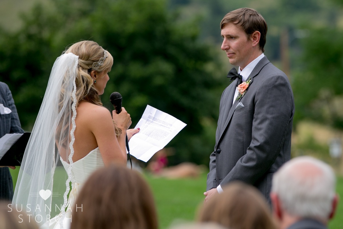 a bride holds a mic and reads vows to her groom