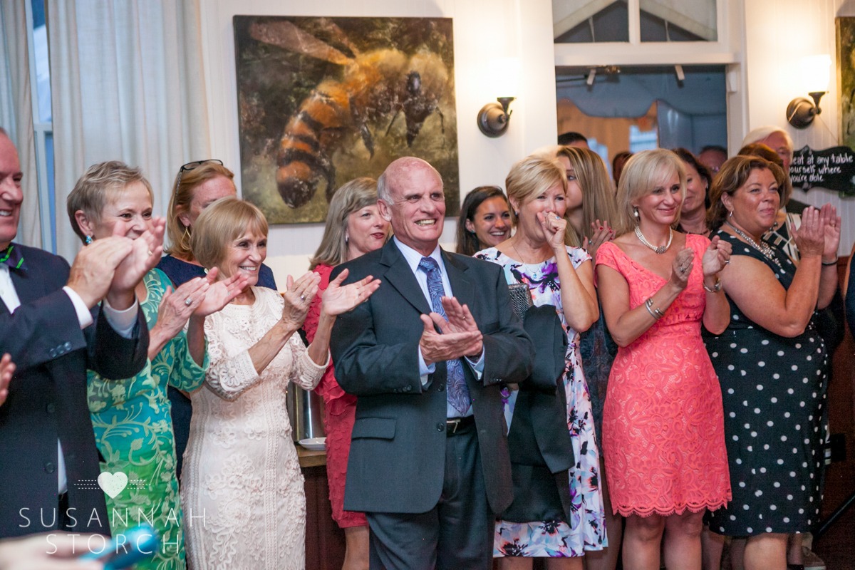 a line of wedding guests clap their hands