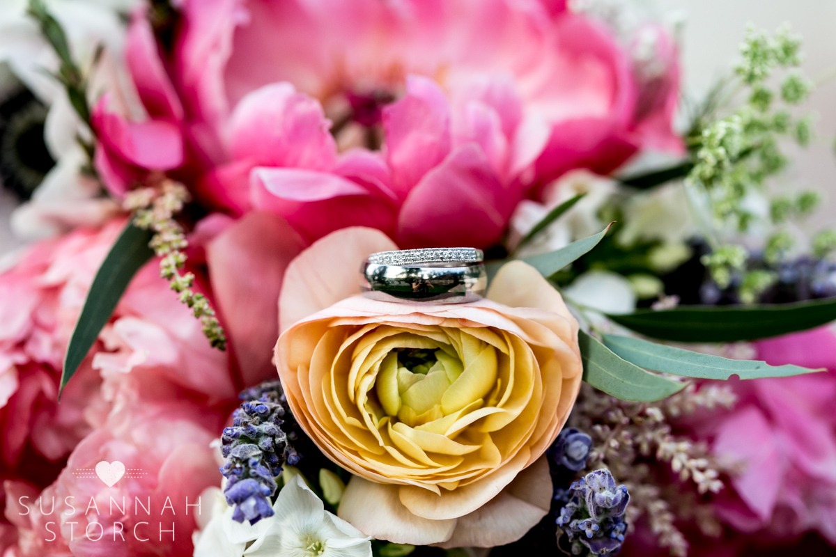 wedding rings sit on a bouquet