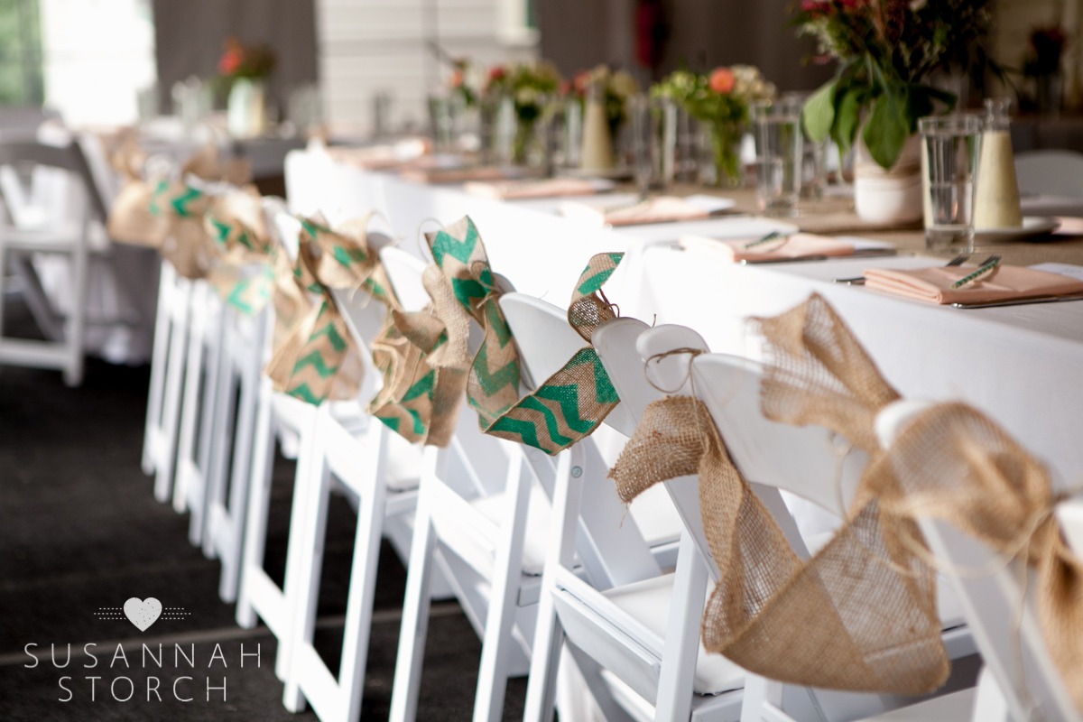 burlap decorates the back of white chairs