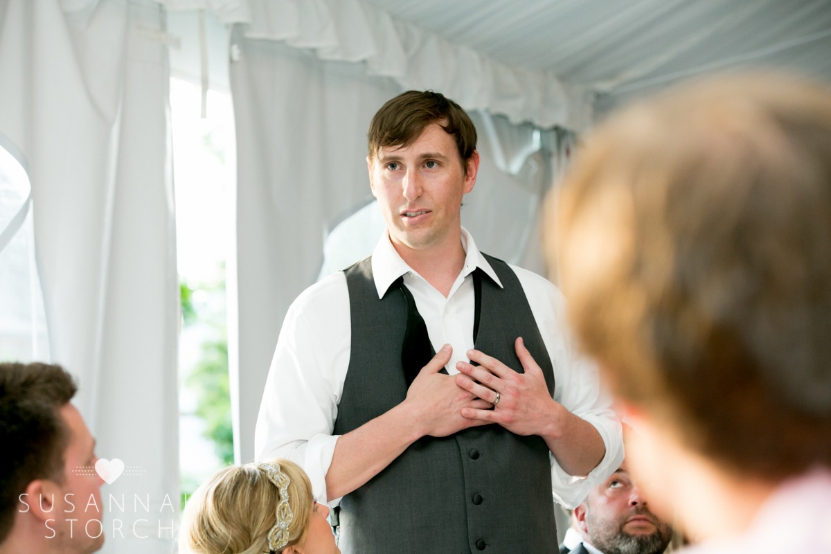a groom puts his hands on his chest while giving a speech