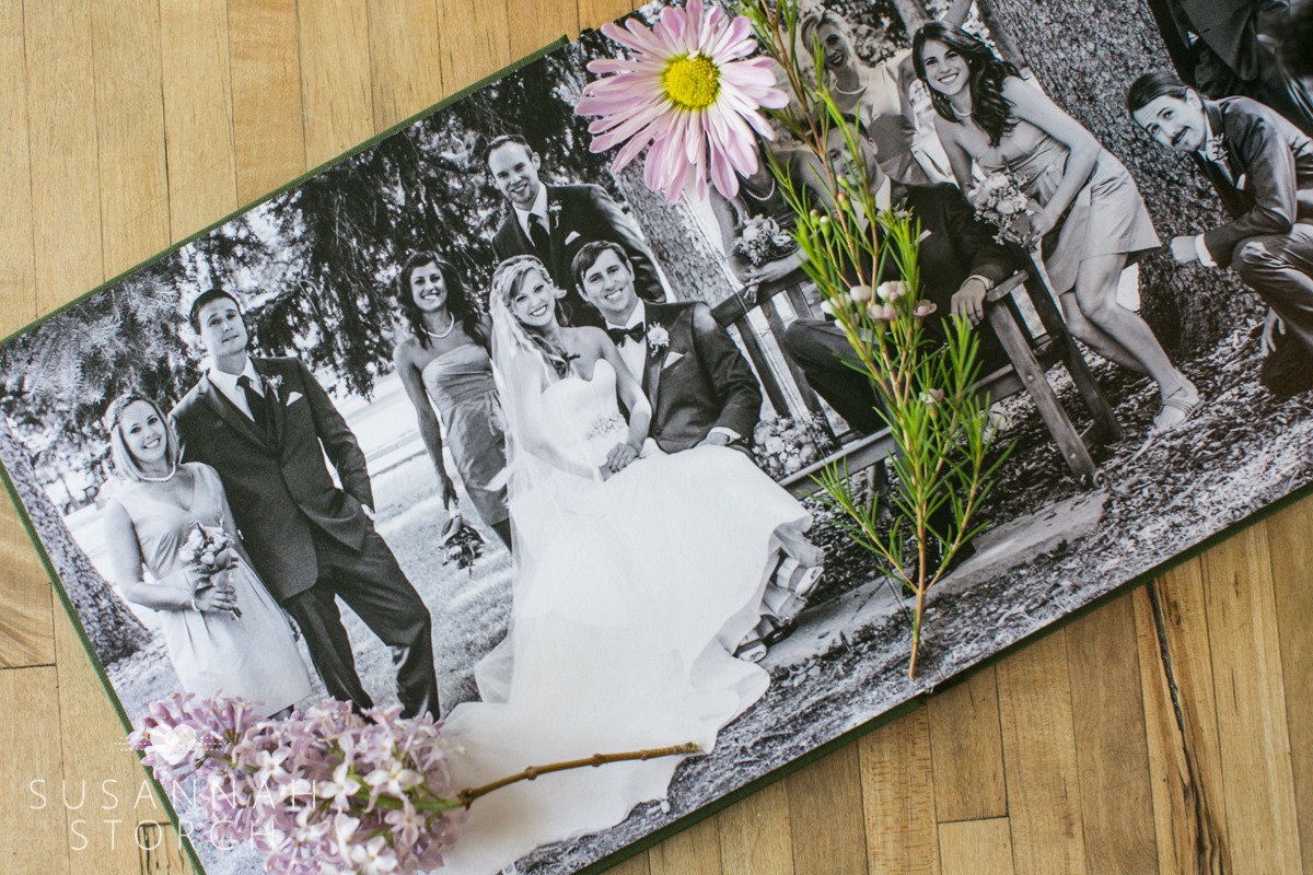 wedding album with flowers on top of photographs