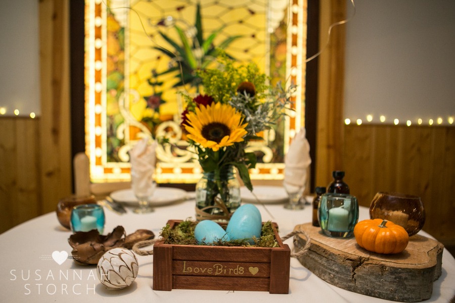 a table decorated with sunflowers, a small pumpkin and other items