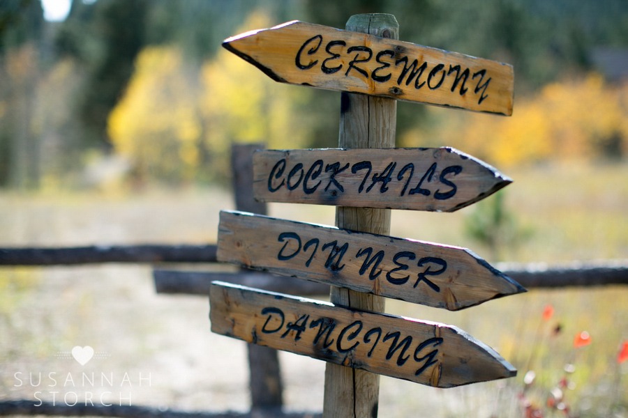 a wooden sign with arrows points wedding guests to different places