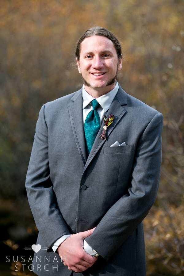 a handsome groom in a teal tie