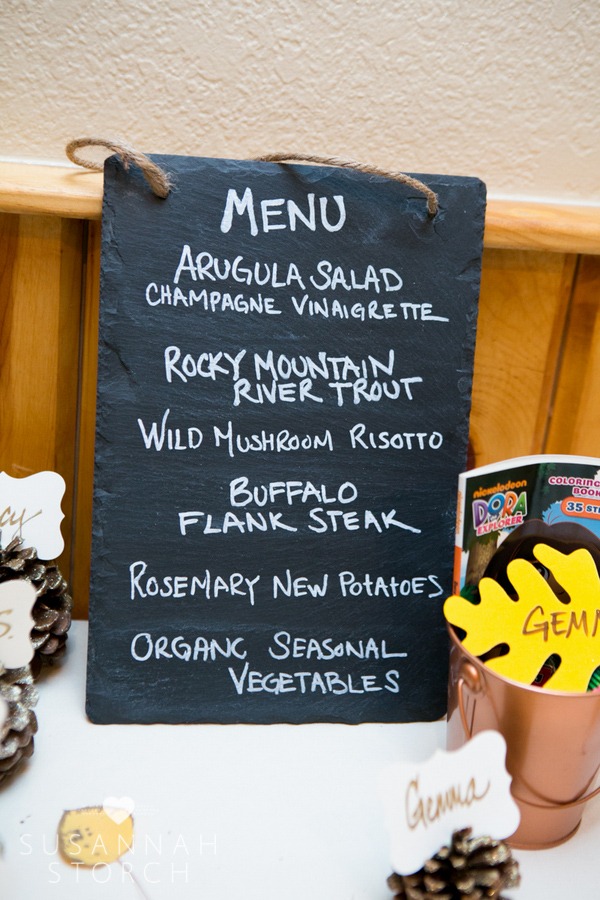 a slate board lists the meal served at a mountain wedding