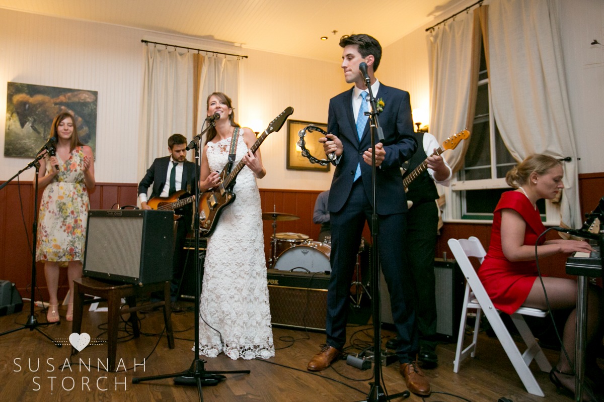 a bride sings into a mic while a groom plays the tambourine