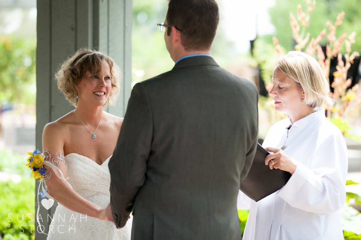 a bride looks at her groom during their outdoor wedding ceremony