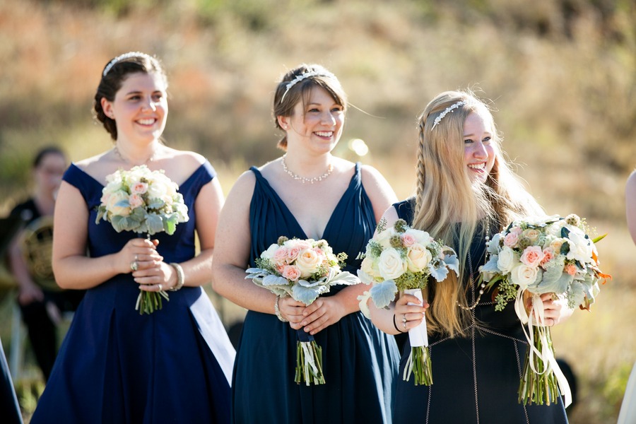 three bridesmaids look happy during a wedding ceremony