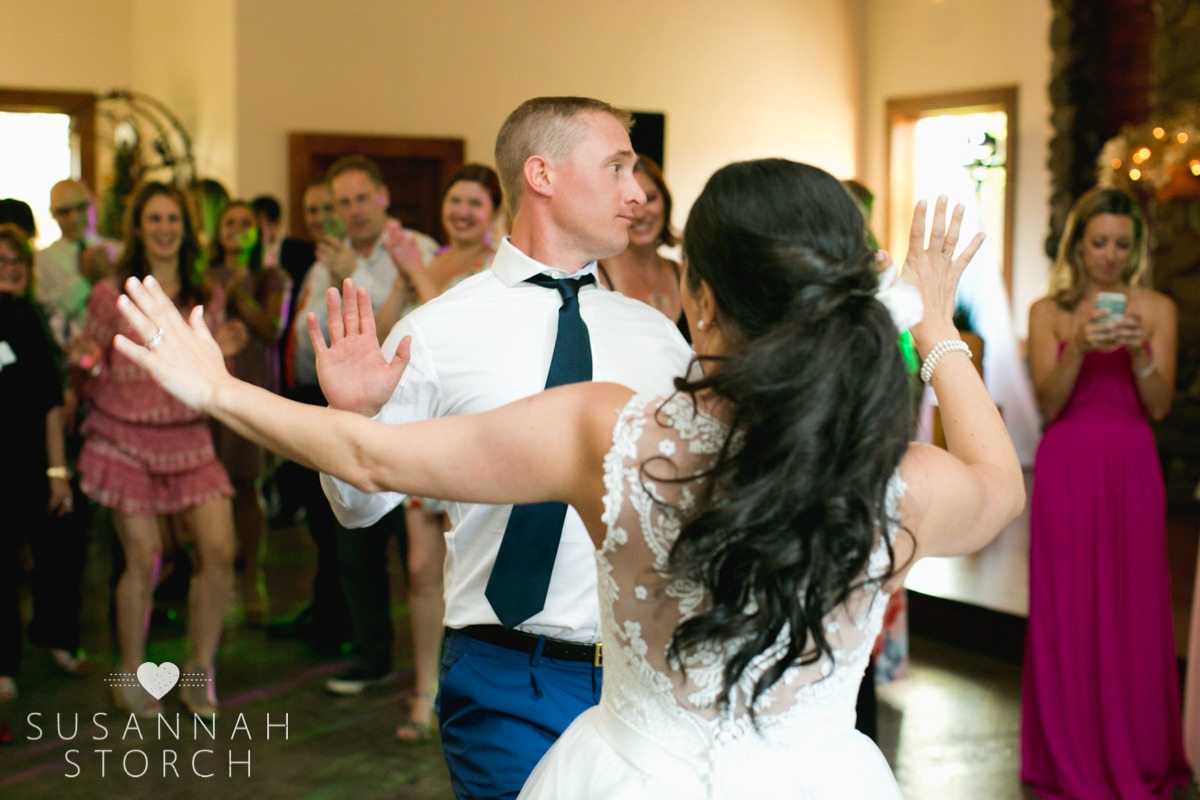 a bride and groom get down while happy wedding guests watch