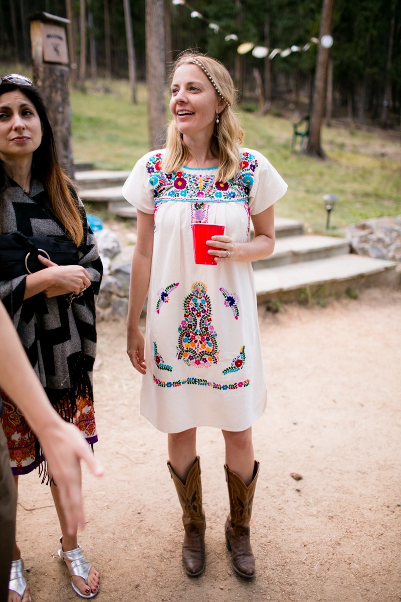 a woman in a mexican dress talks to wedding guests