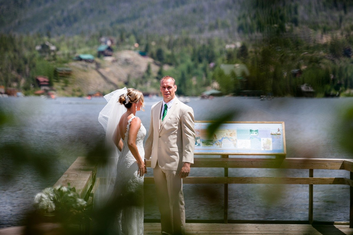 a groom stands on a deck at grand lake colorado