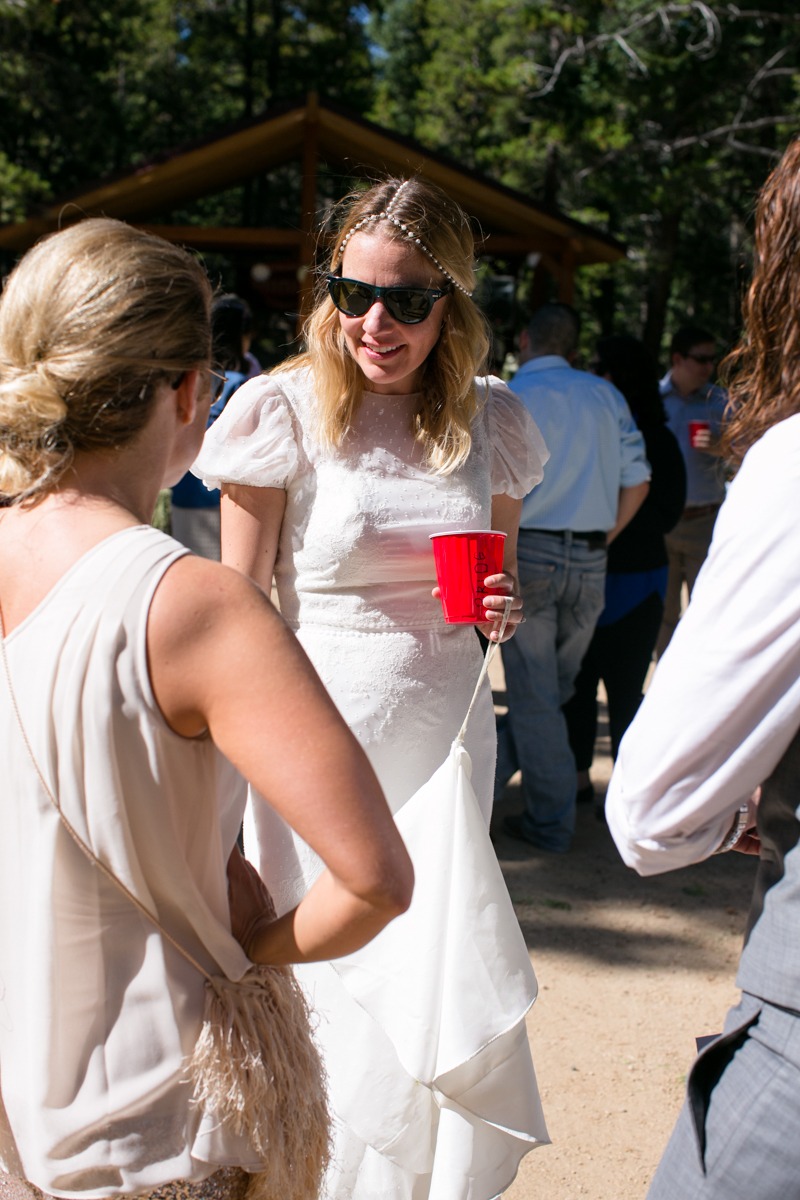 a bride with a red solo cup chats to wedding guests