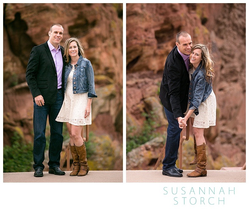 a man and woman pose in front of a rock wall at red rocks
