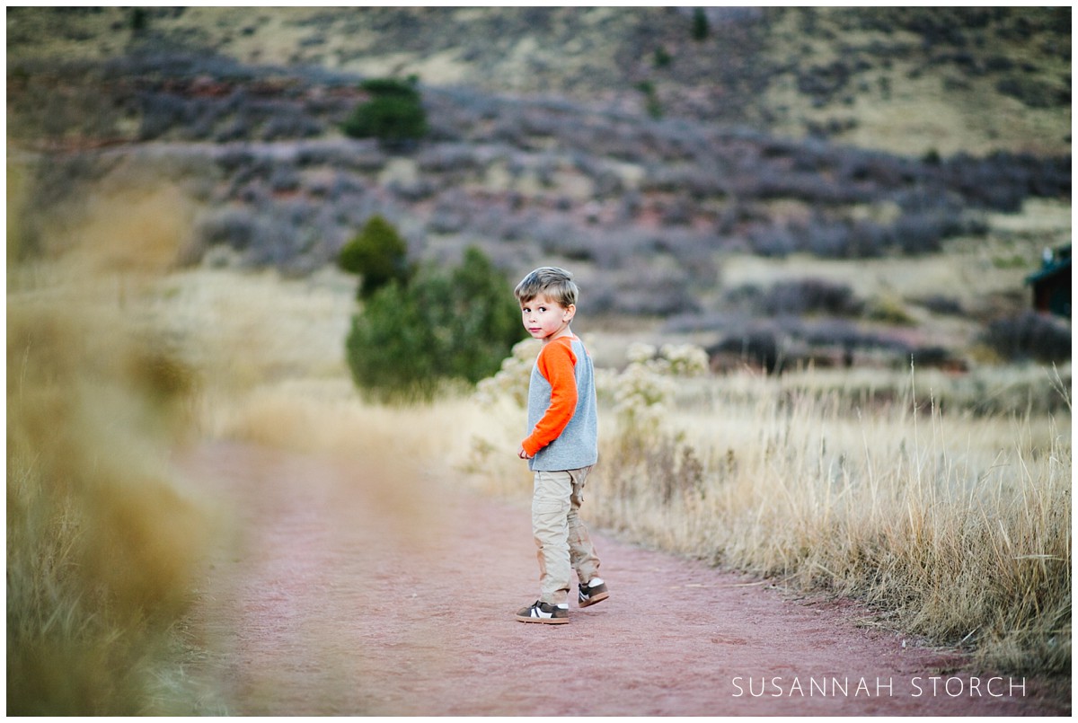 a boy turns around on a colorado hiking trail