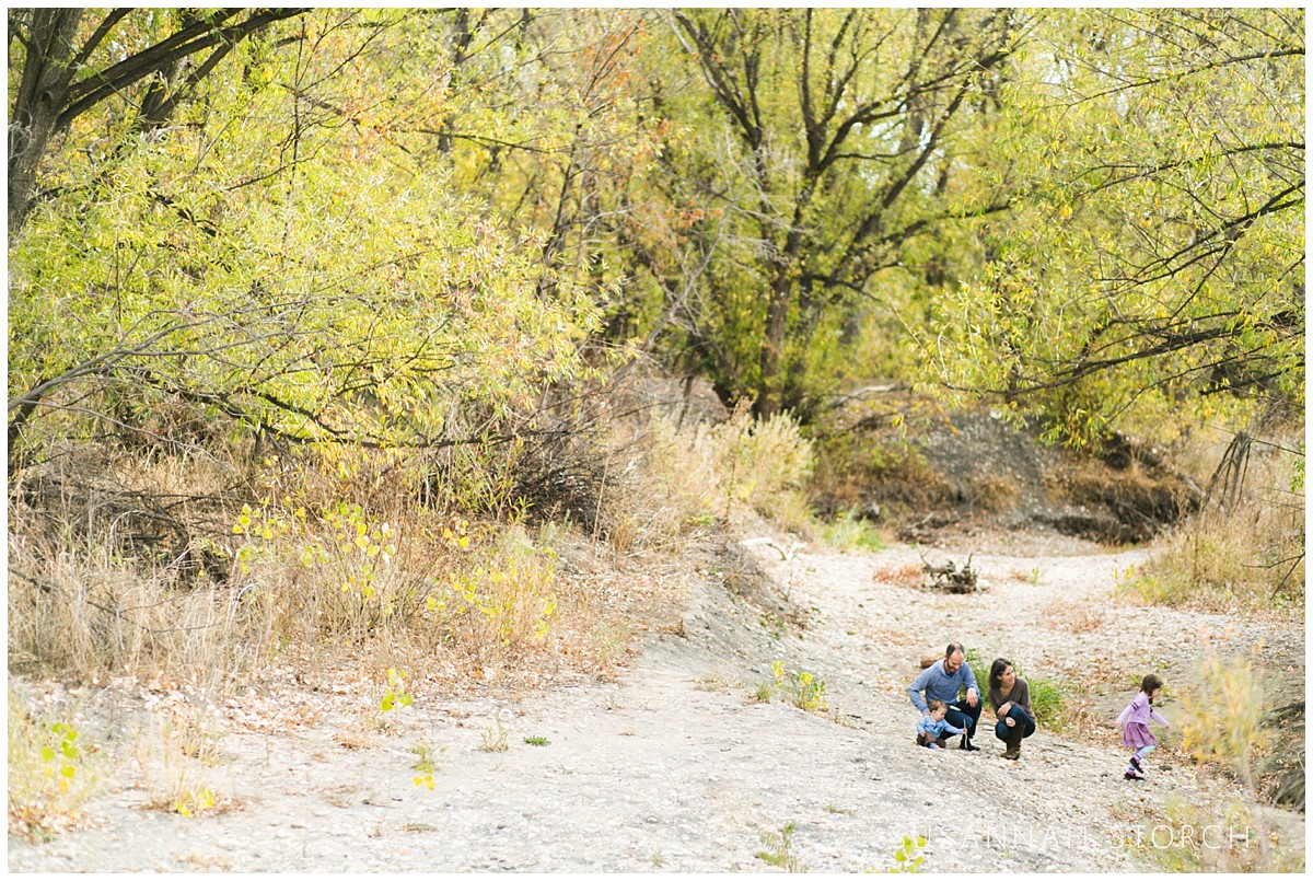 a family huddles in a dry river area