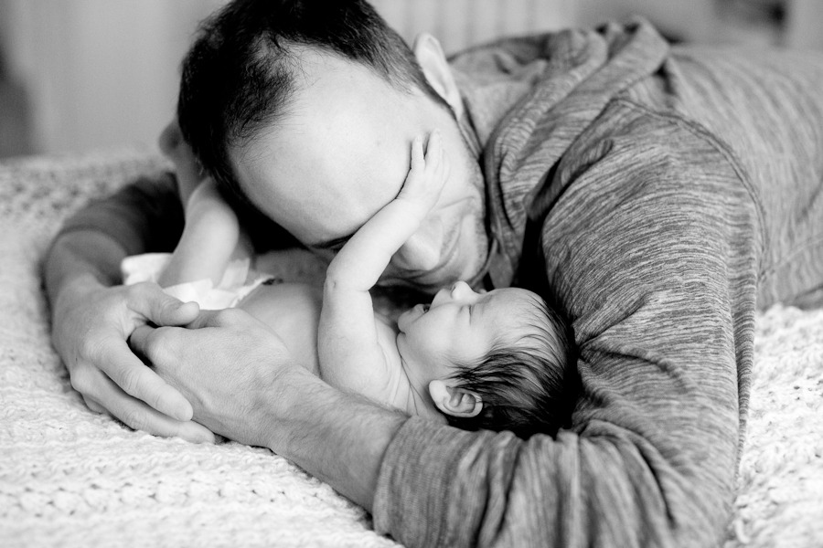 a dad snuggles his newborn daughter