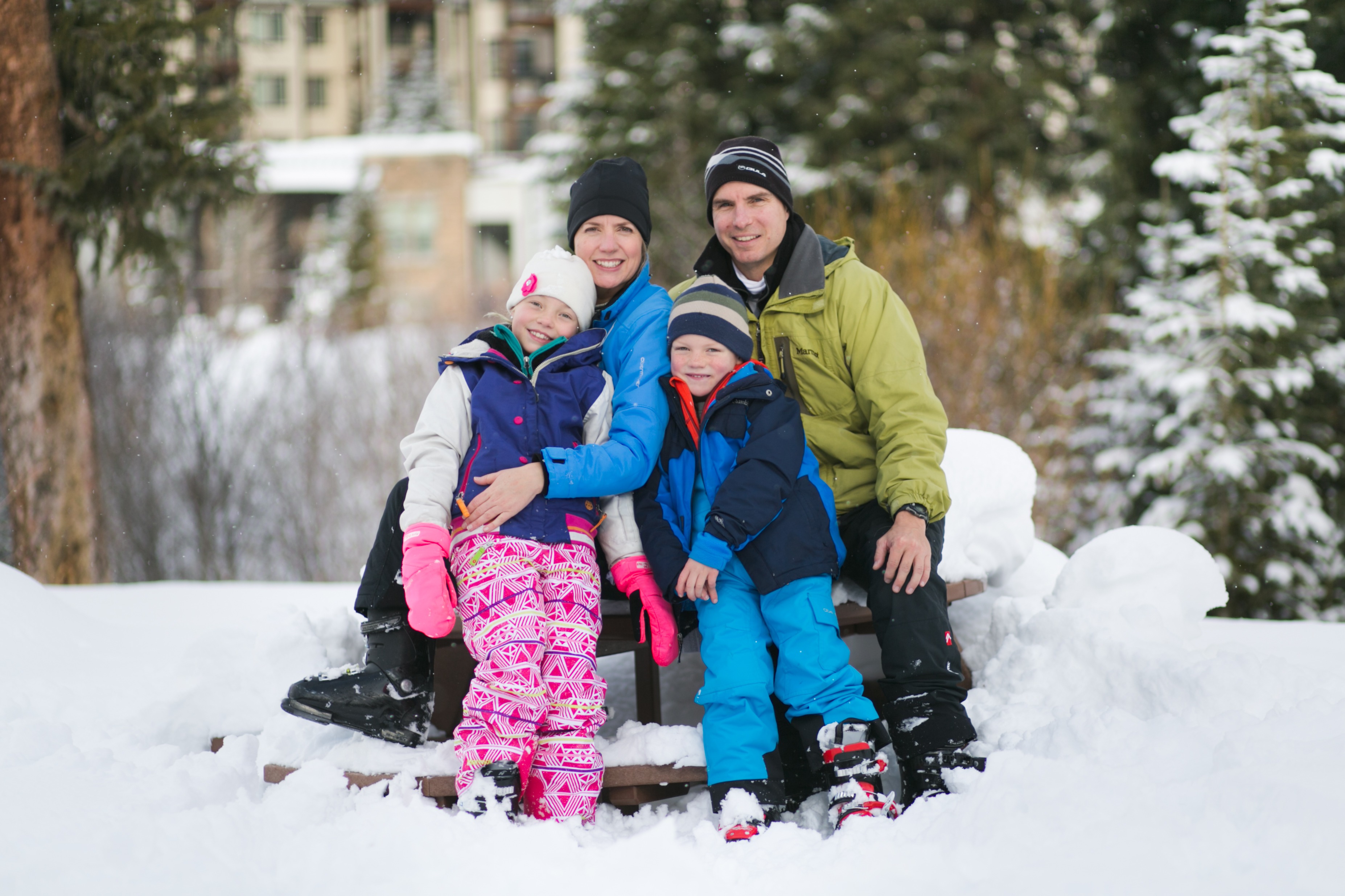 a family of four poses with their snow gear on