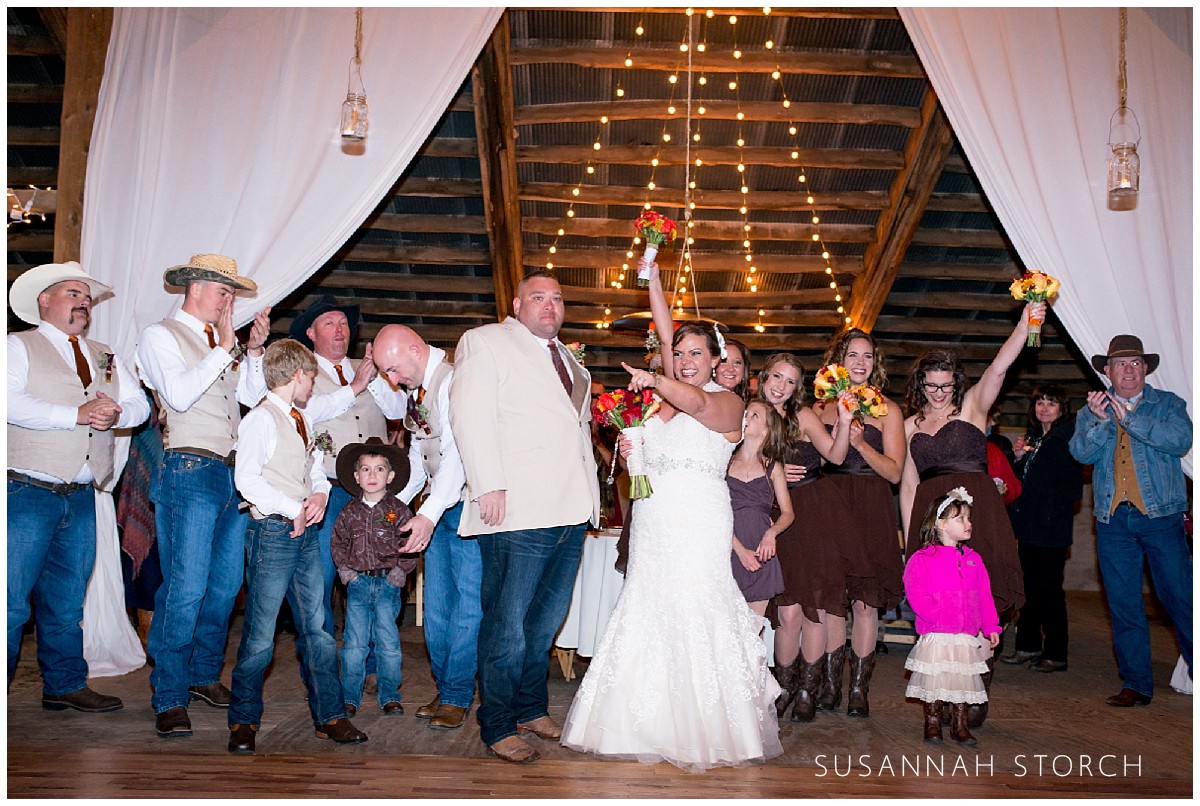 happy wedding couple and party in a barn a