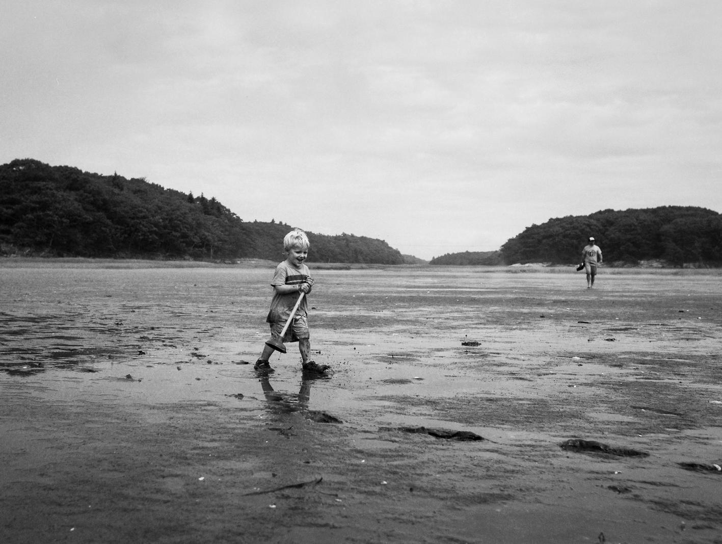 A boy happily carries a plunger in the Sagadahoc Bay in Maine