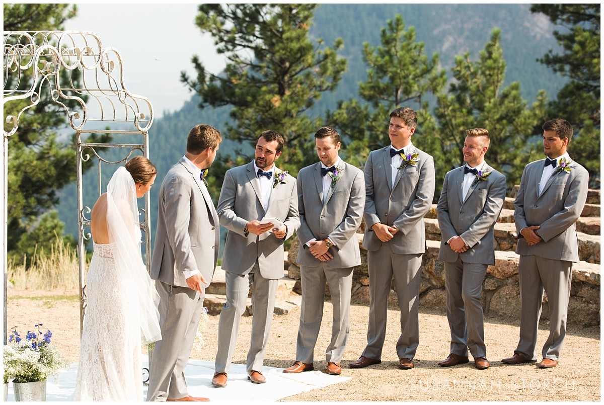 groomsmen stand in a line during an outdoor wedding ceremony