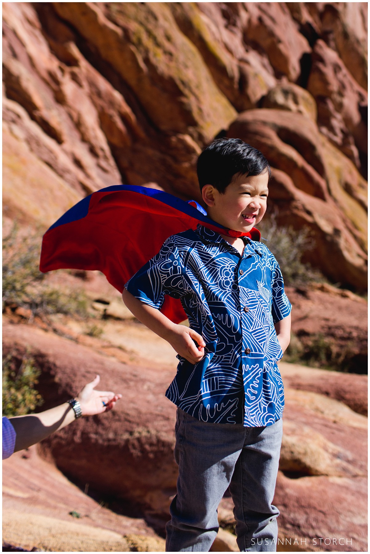 A parent fluffs his sons super hero cape in morrison, colorado