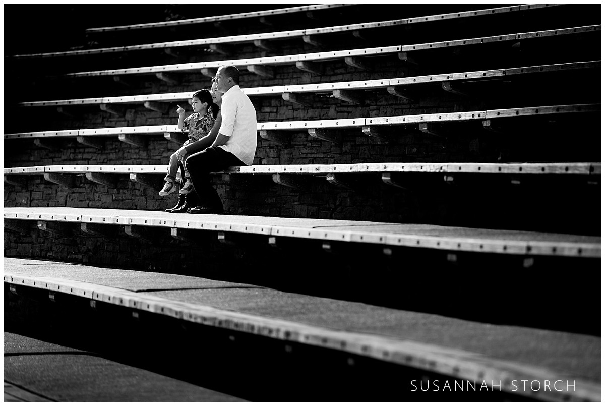 A family sits on the steps at Red Rocks Amphitheater