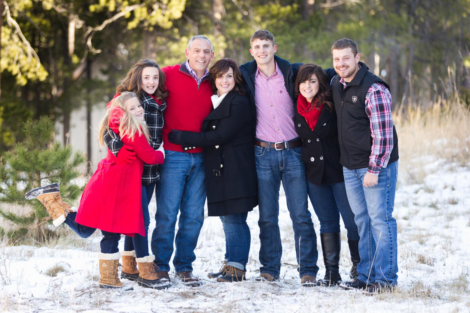 A family hangs out in the snow in Nederland Colorado during a photography session.