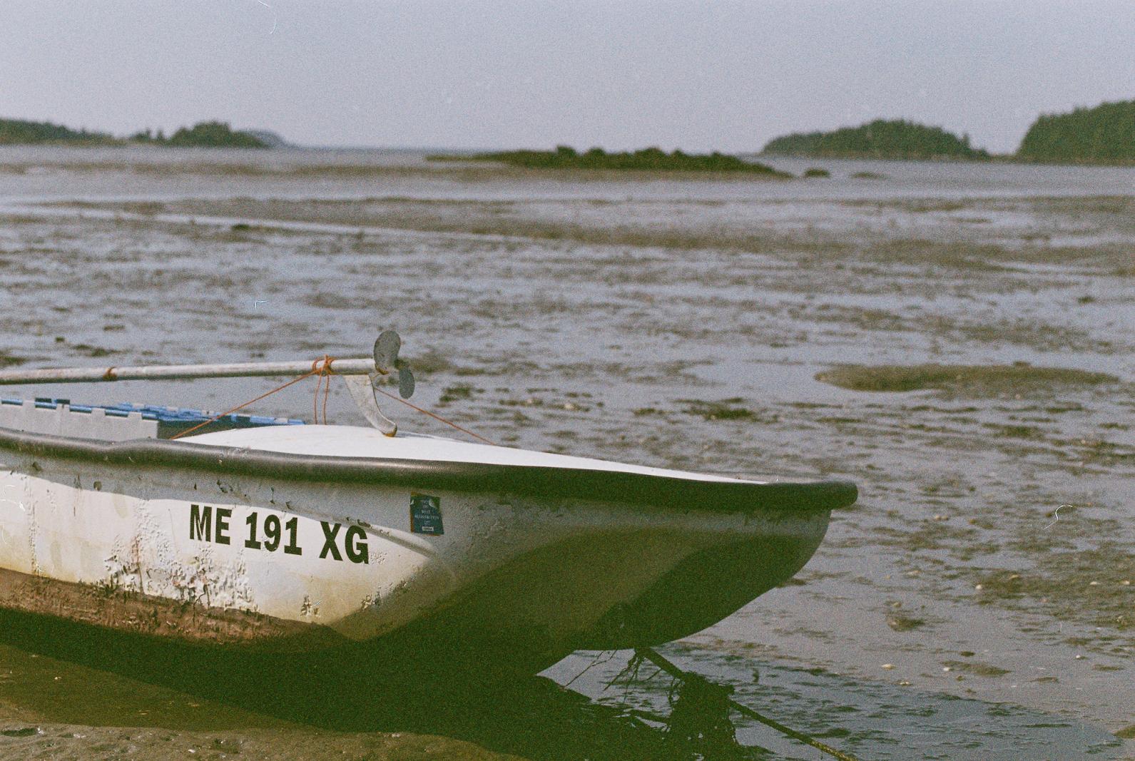 a boat sitting in mudflats at lowtide