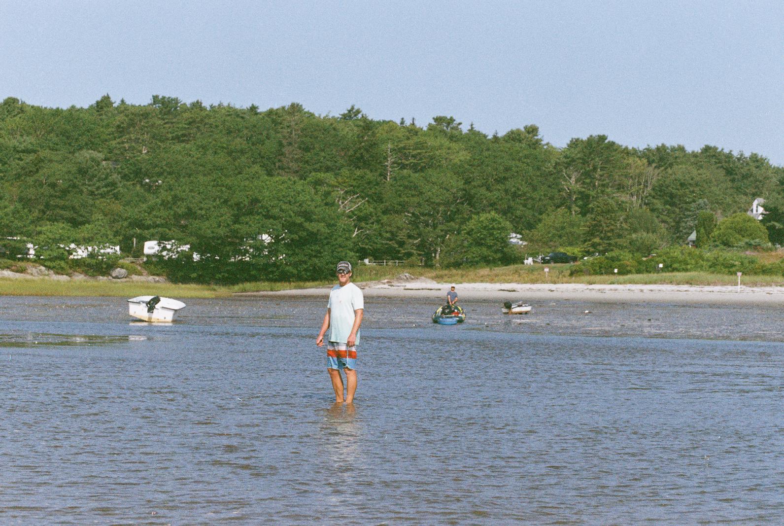 a man standing in water at lowtide
