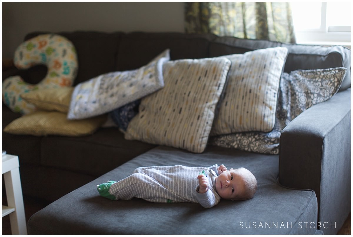 a baby lies on a couch