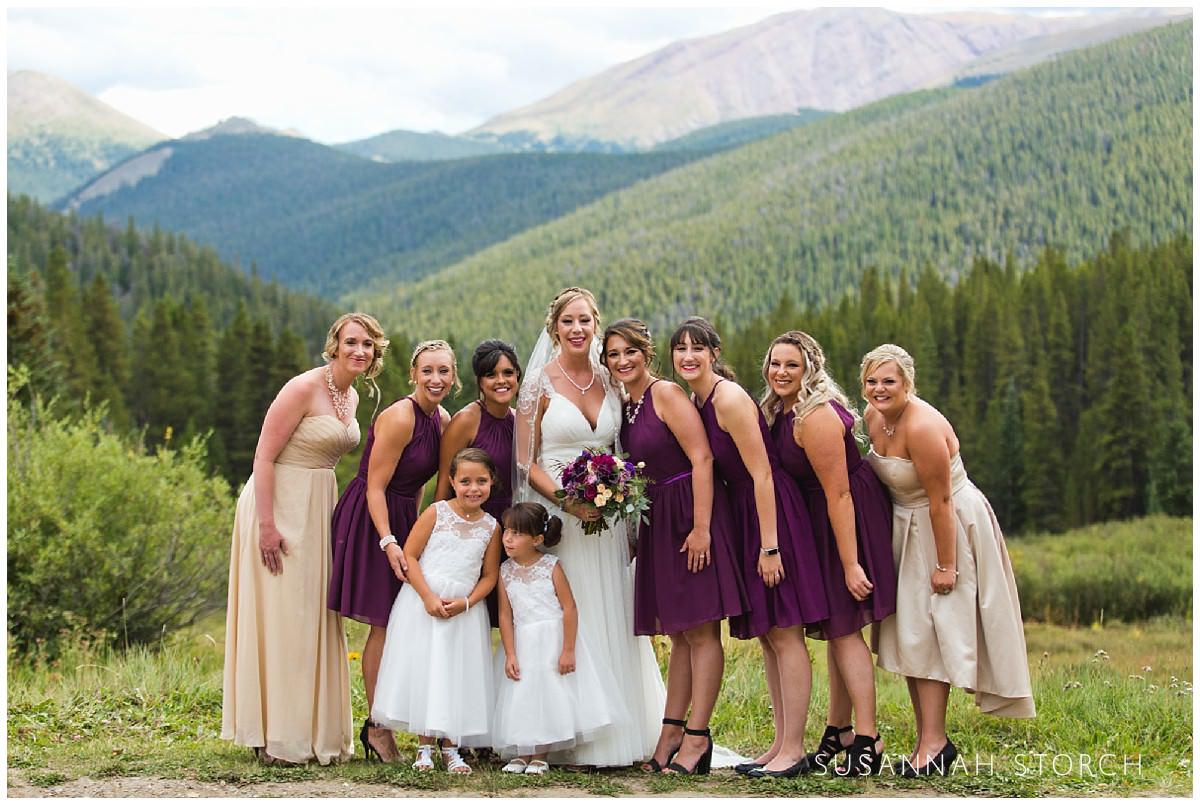 bridal party poses in front of mountains