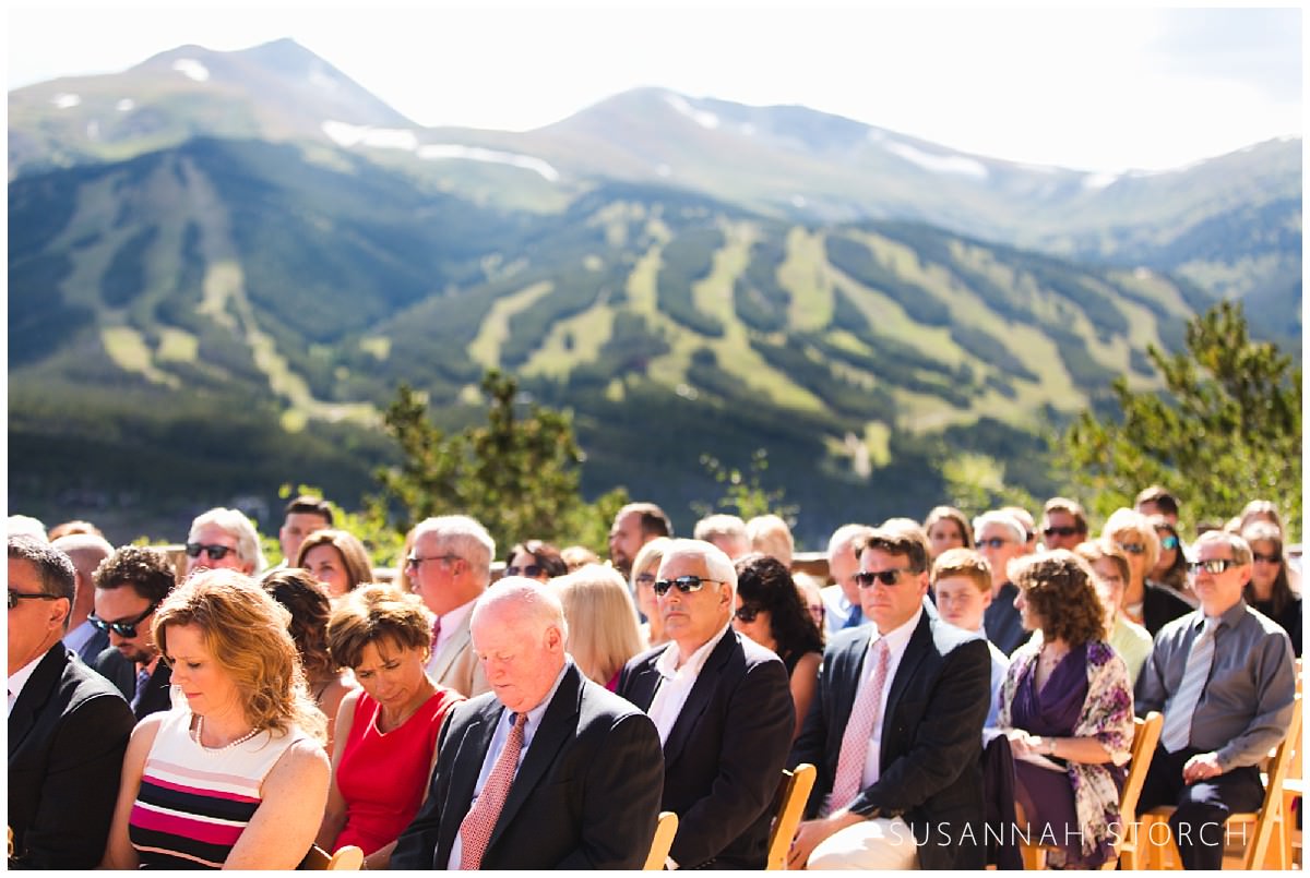 guests wait for a wedding to start on a deck in front of the breckenridge ski hill