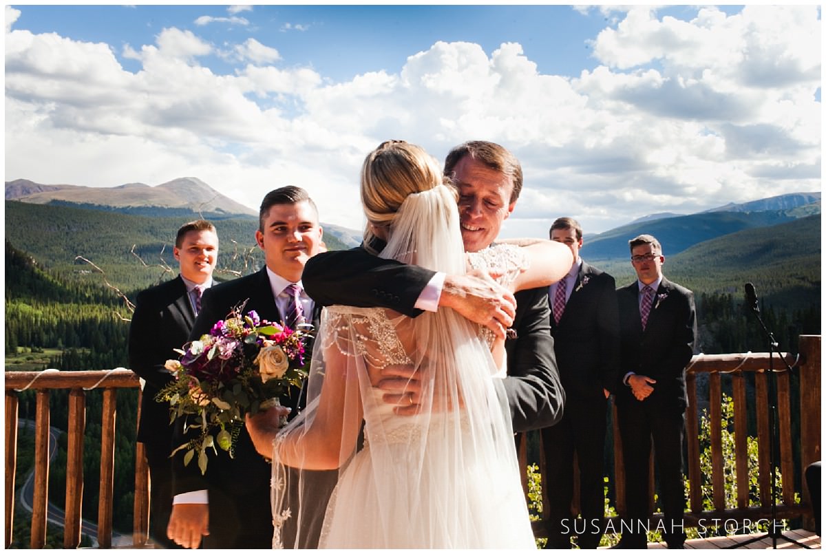 a dad hugs his daughter the bride at her wedding ceremony