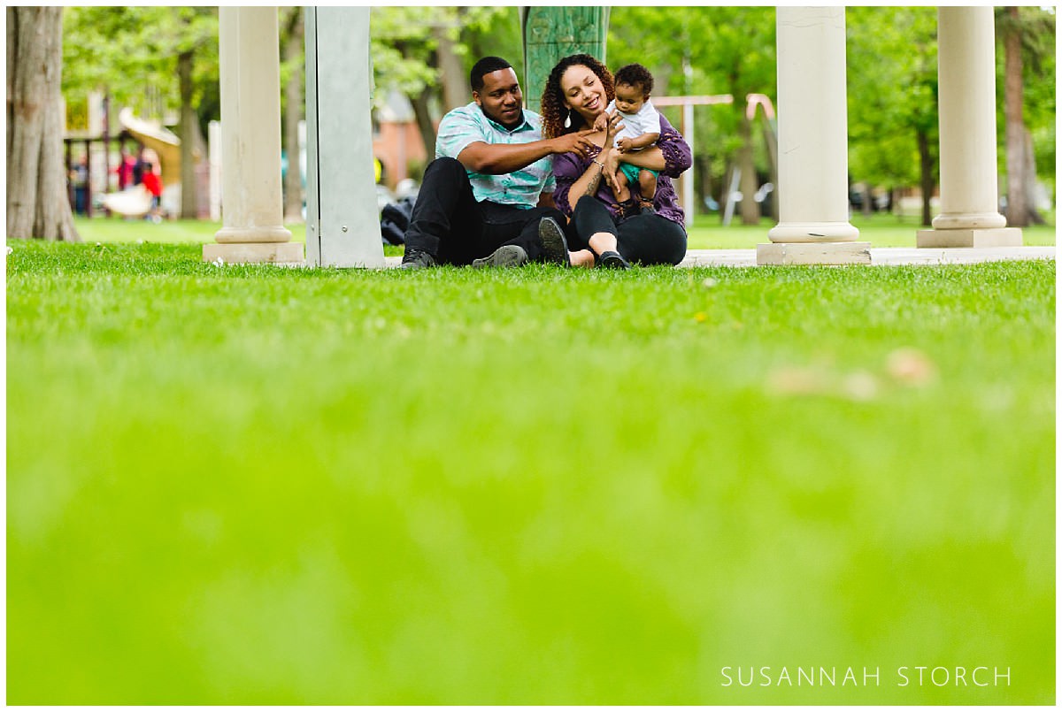 a family sits on bright green grass