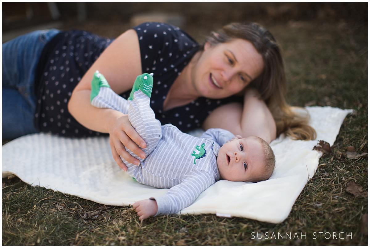 a mom looks at her baby son as he looks at camera