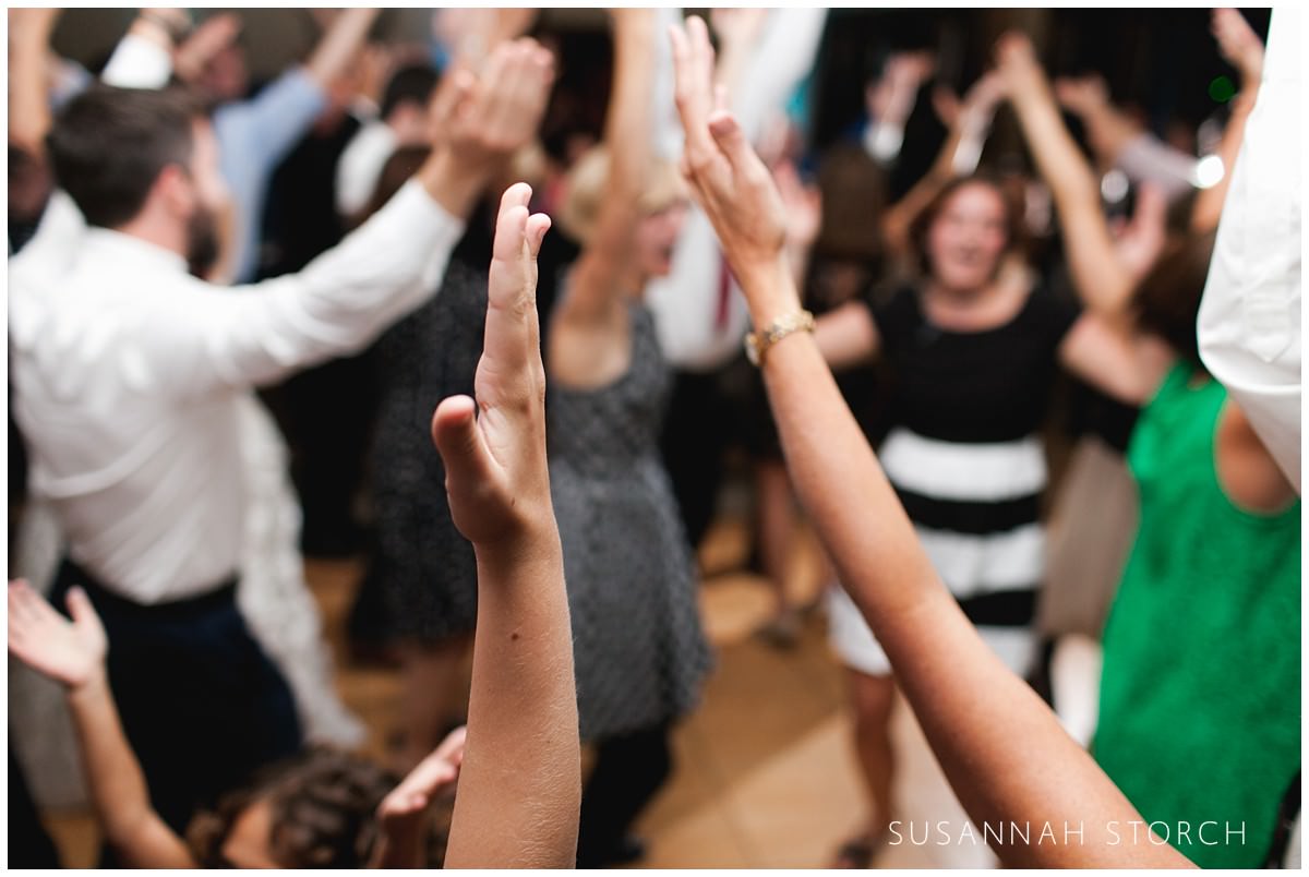 hands raised up in the air during wedding reception dancing