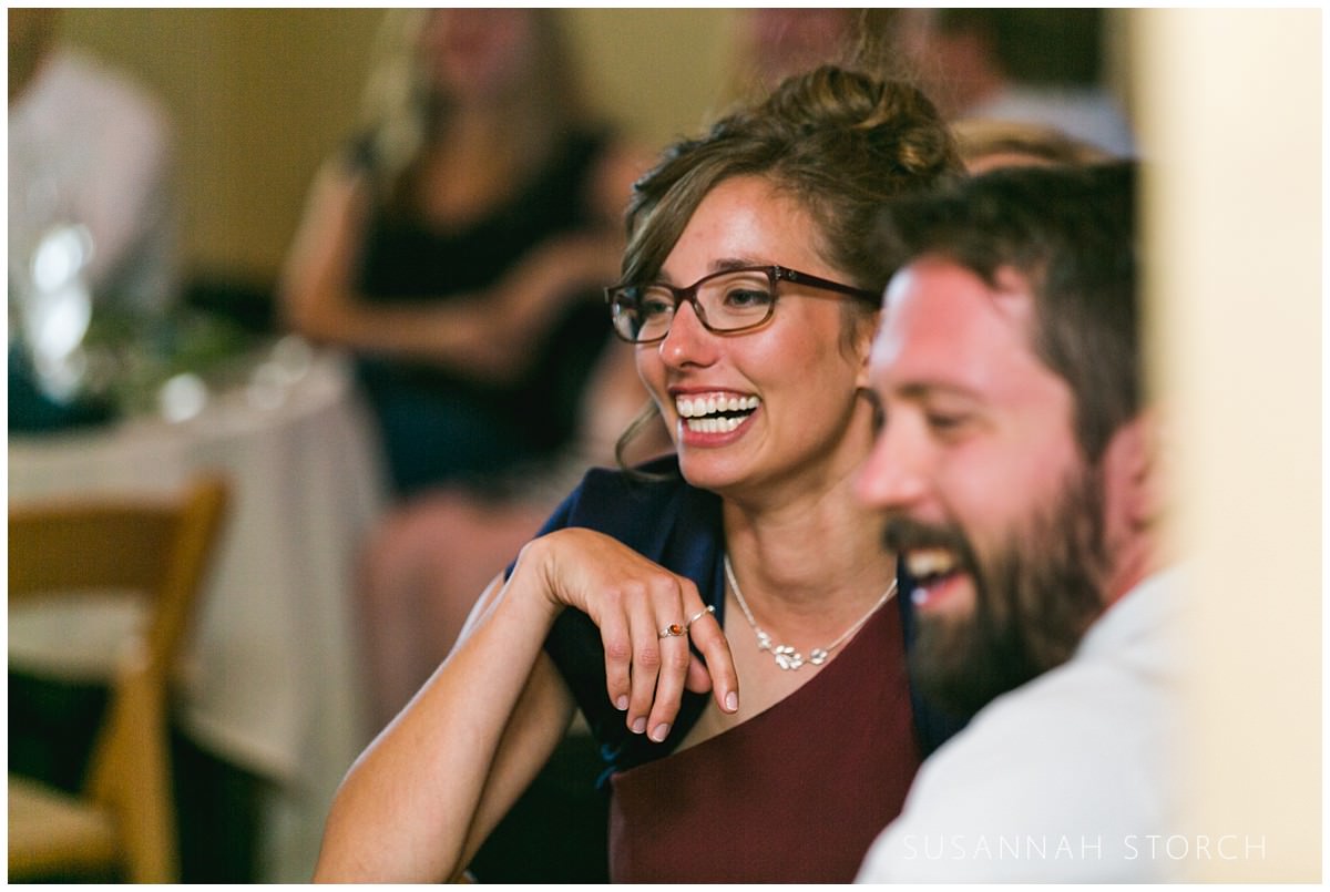 a guest laughs during a wedding reception toast