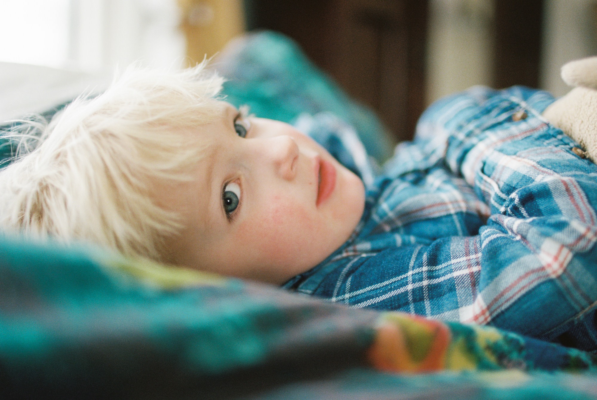 a boy lying down in a bed