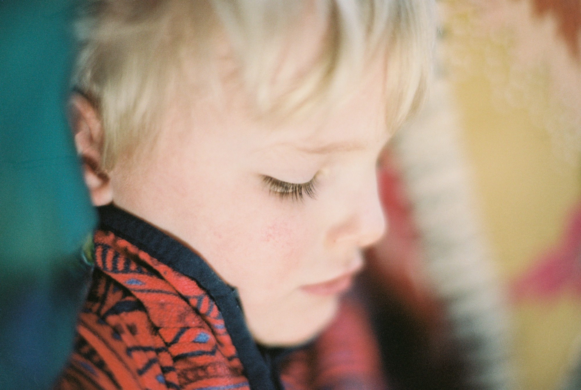 a young blonde boy looks down