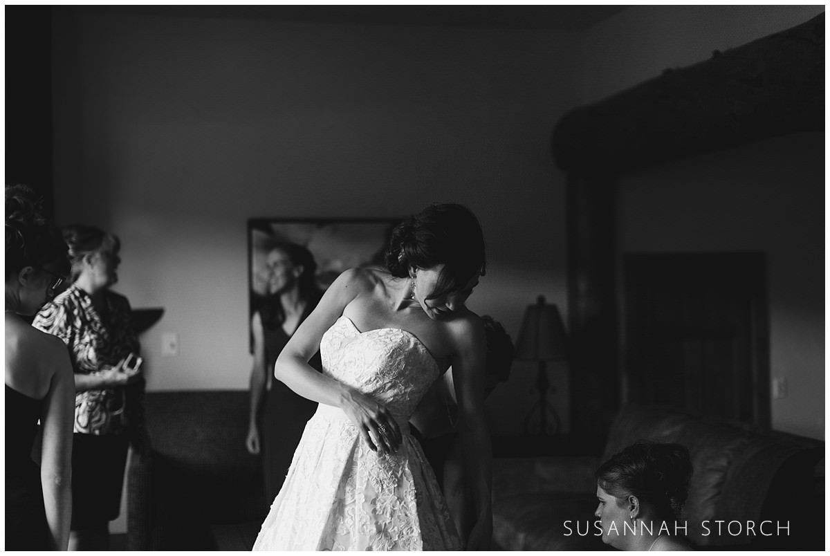black and white photo of a bride getting dressed