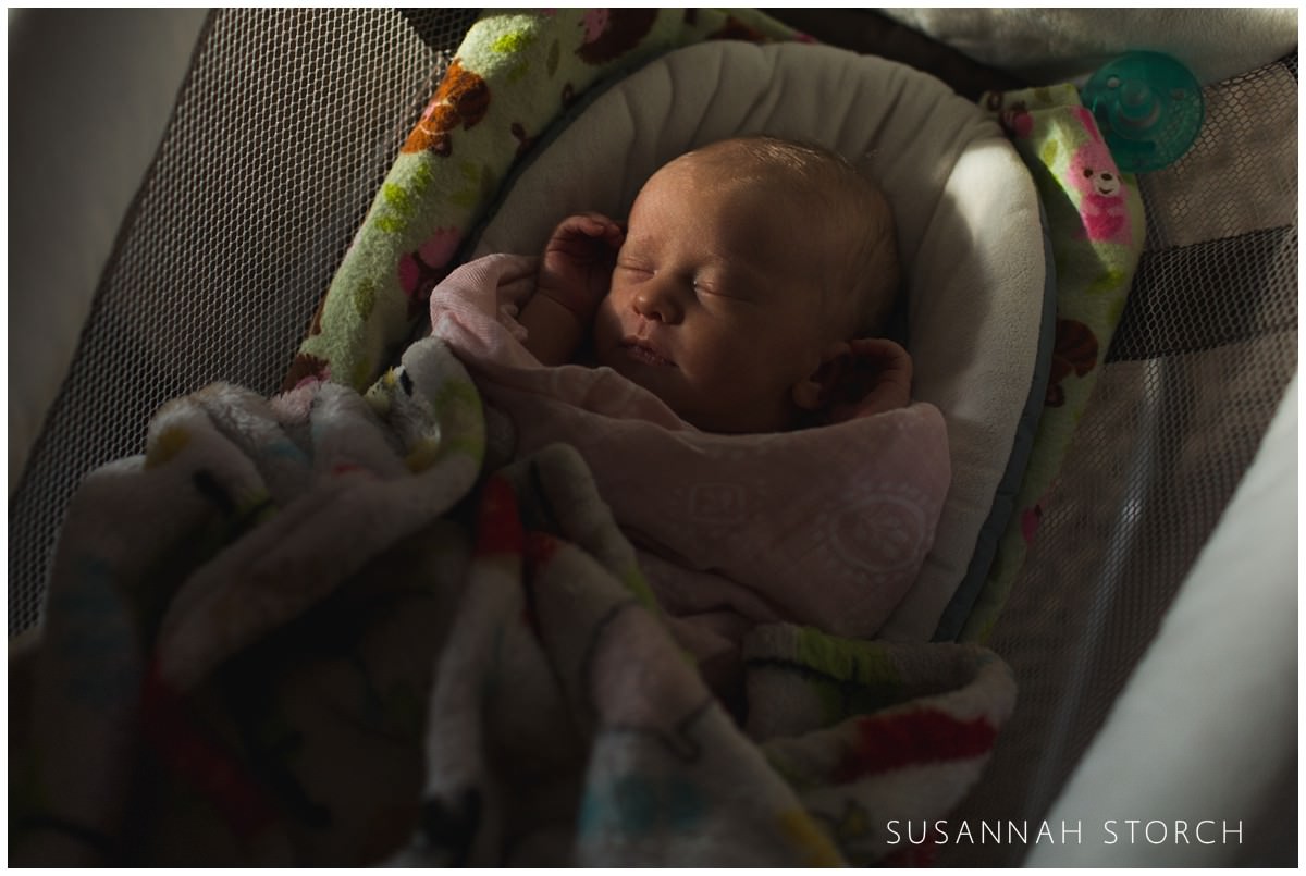 a newborn baby girl sleeps in a cradle