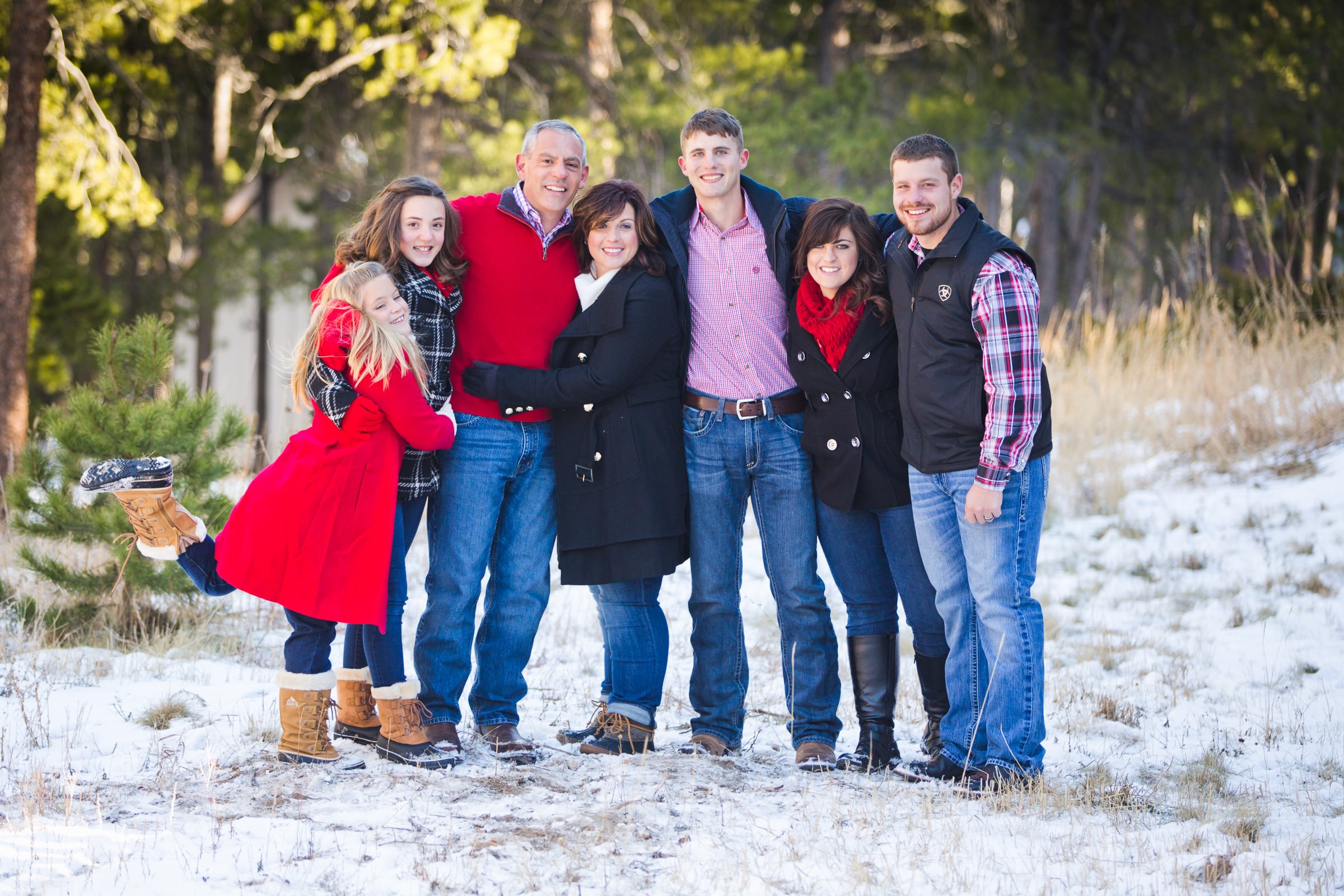 a good-looking family poses in a snowy yard