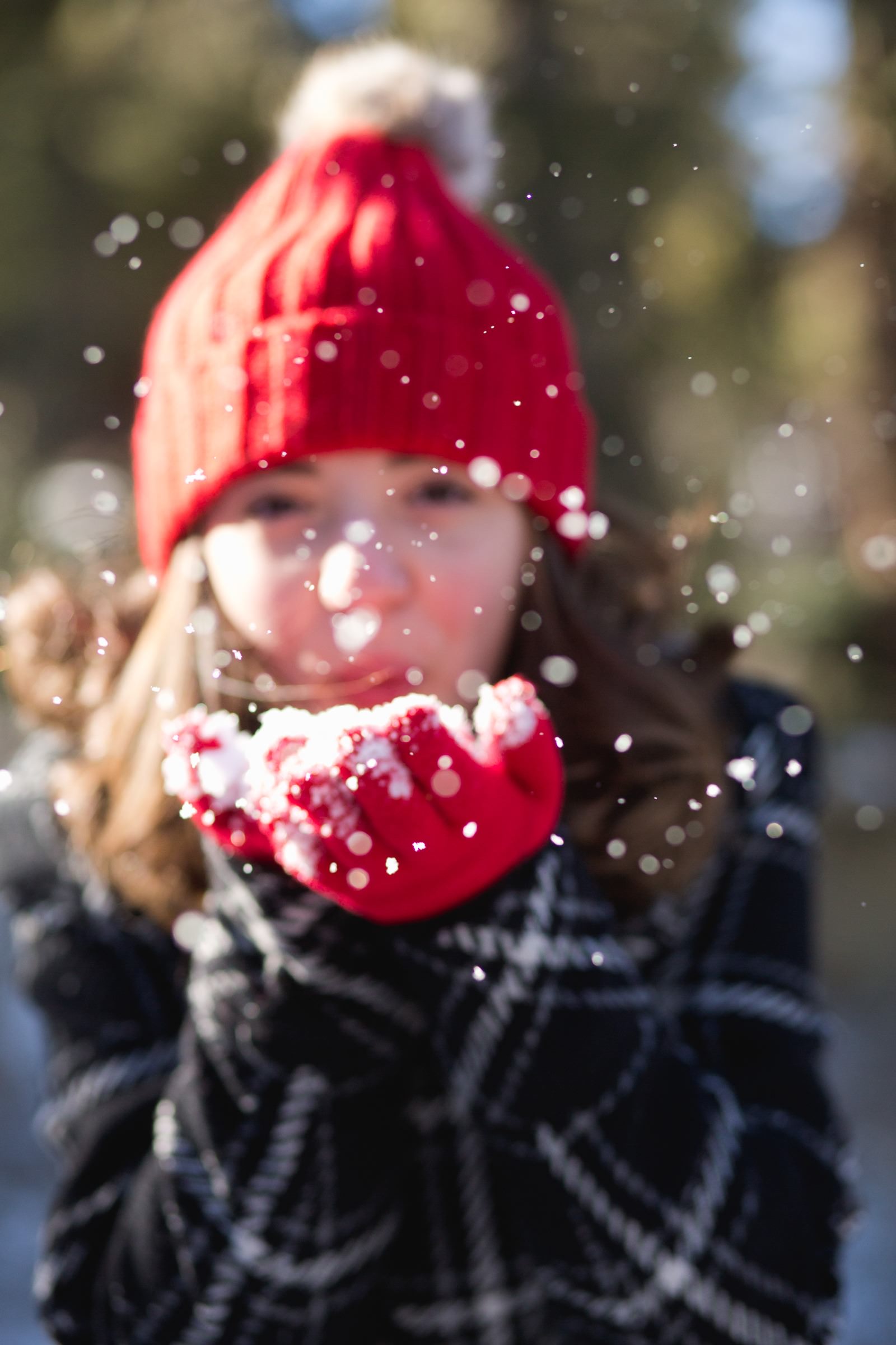 a girl blows snow from her hands