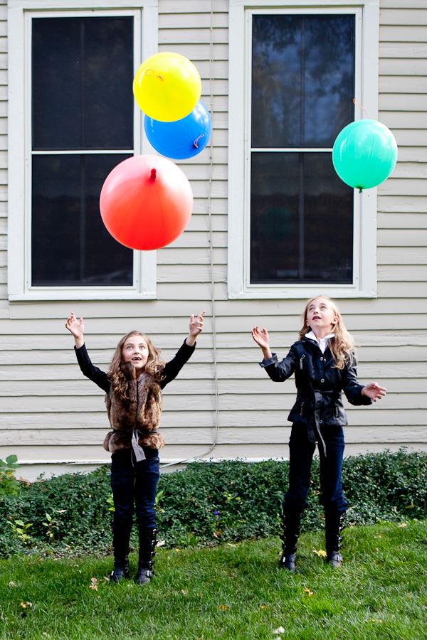 portraits of sisters playing with balloons