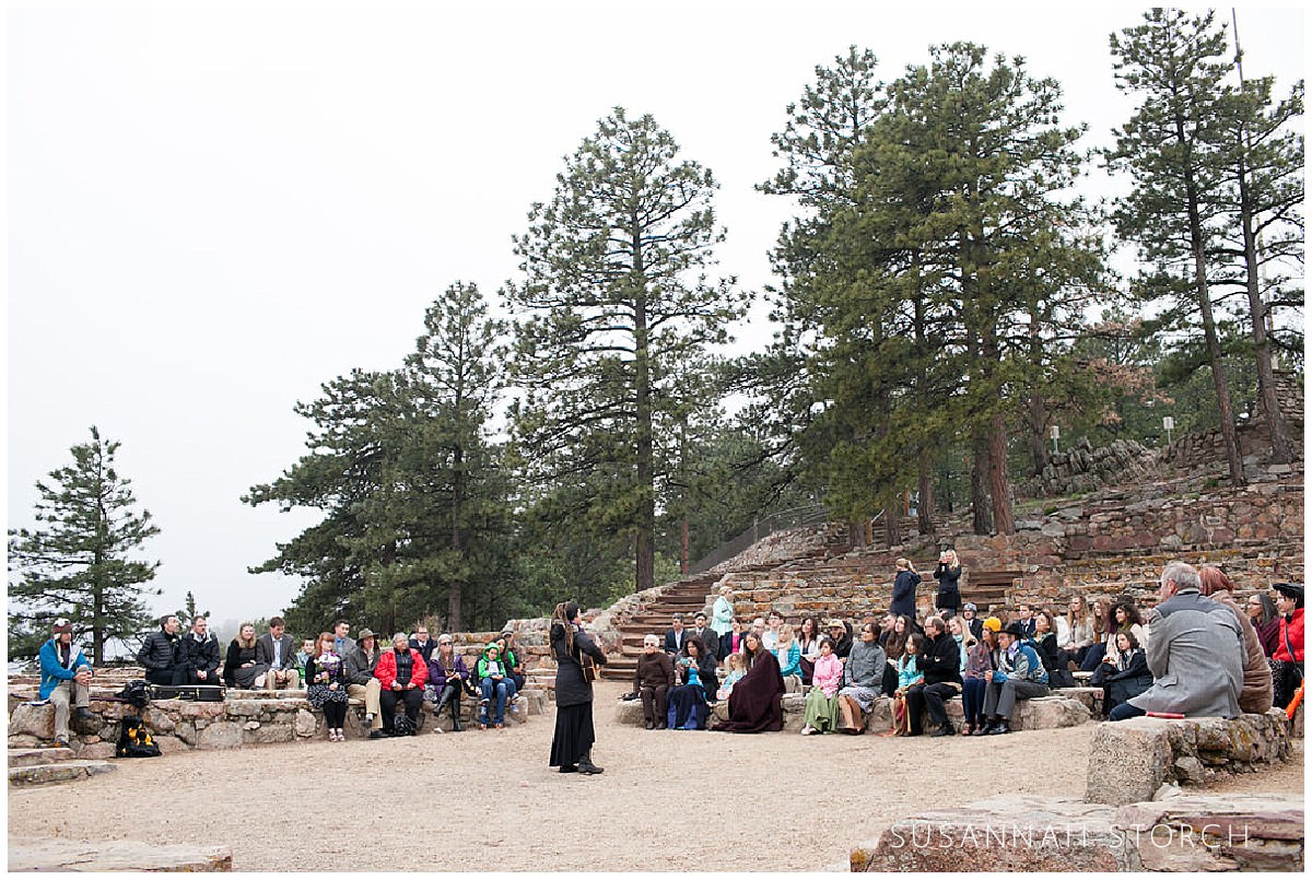 a wedding guest serenades other guests at a mountain wedding ceremony