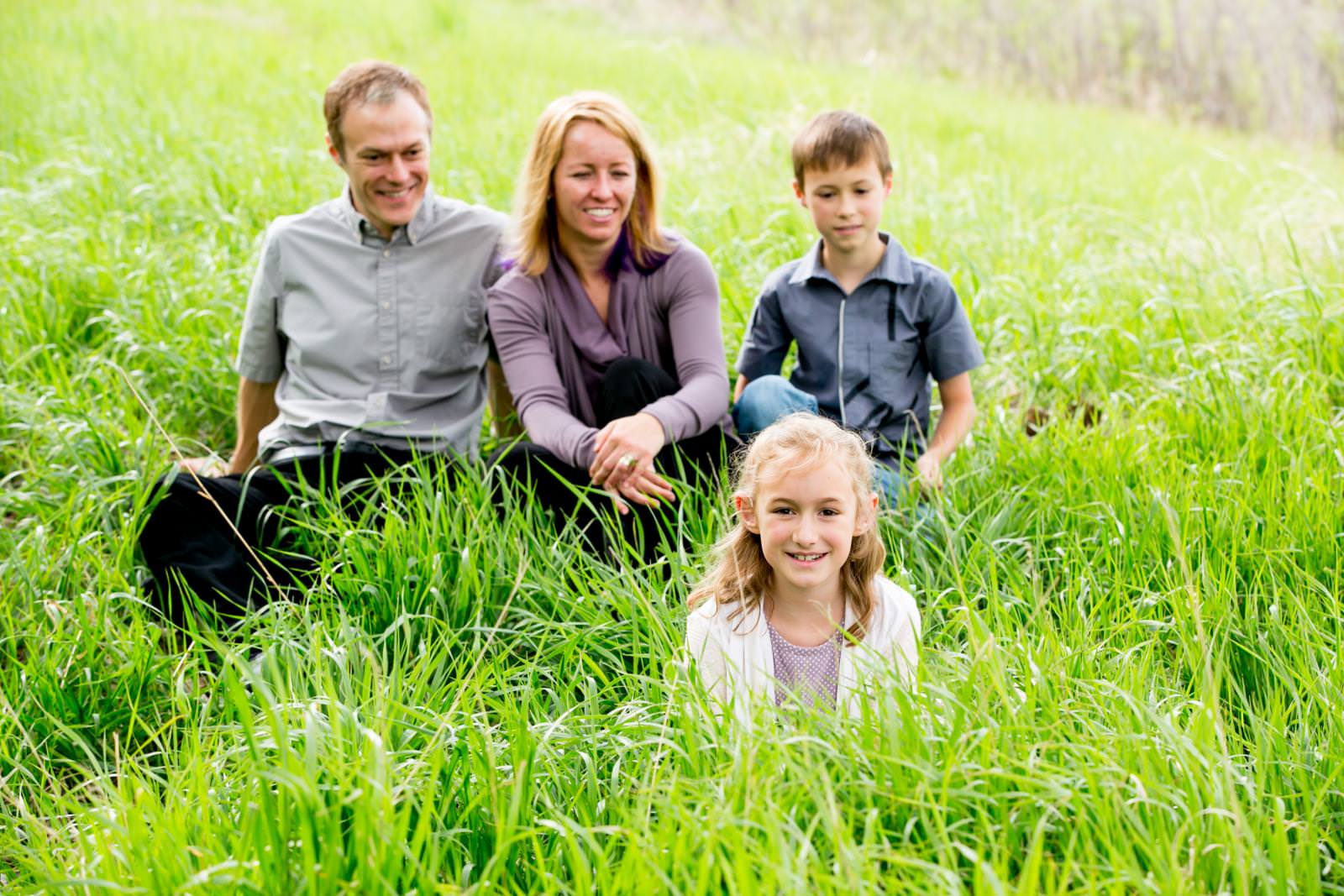 a family sits in tall green grass