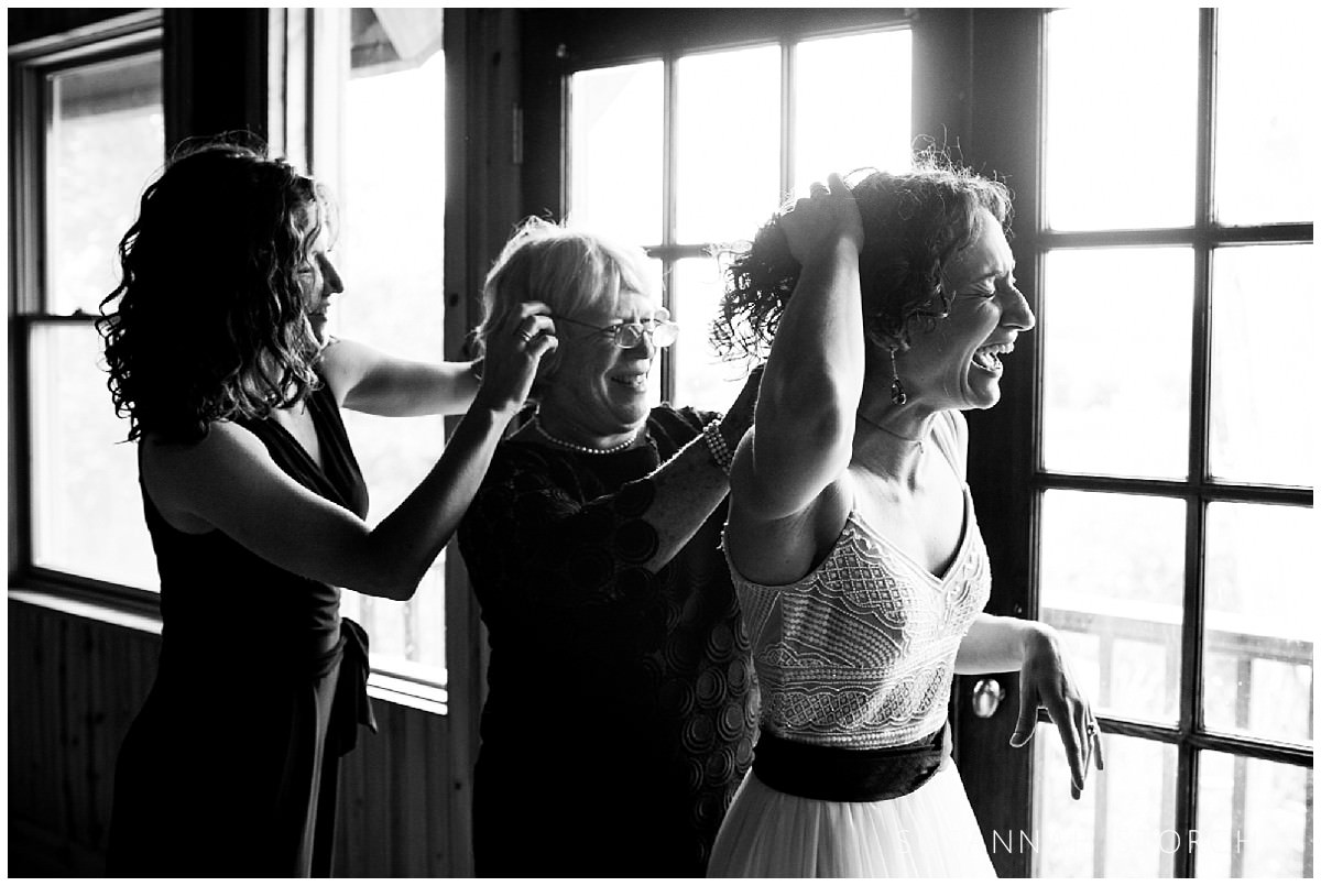 a bride and her immediate family laugh while getting ready