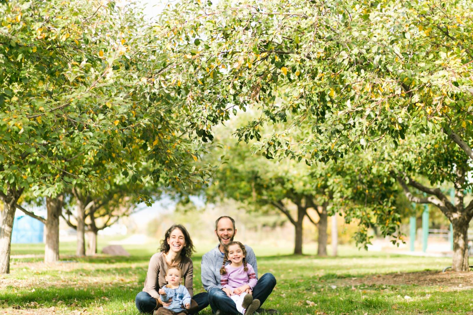 a family sits in front of an orchard